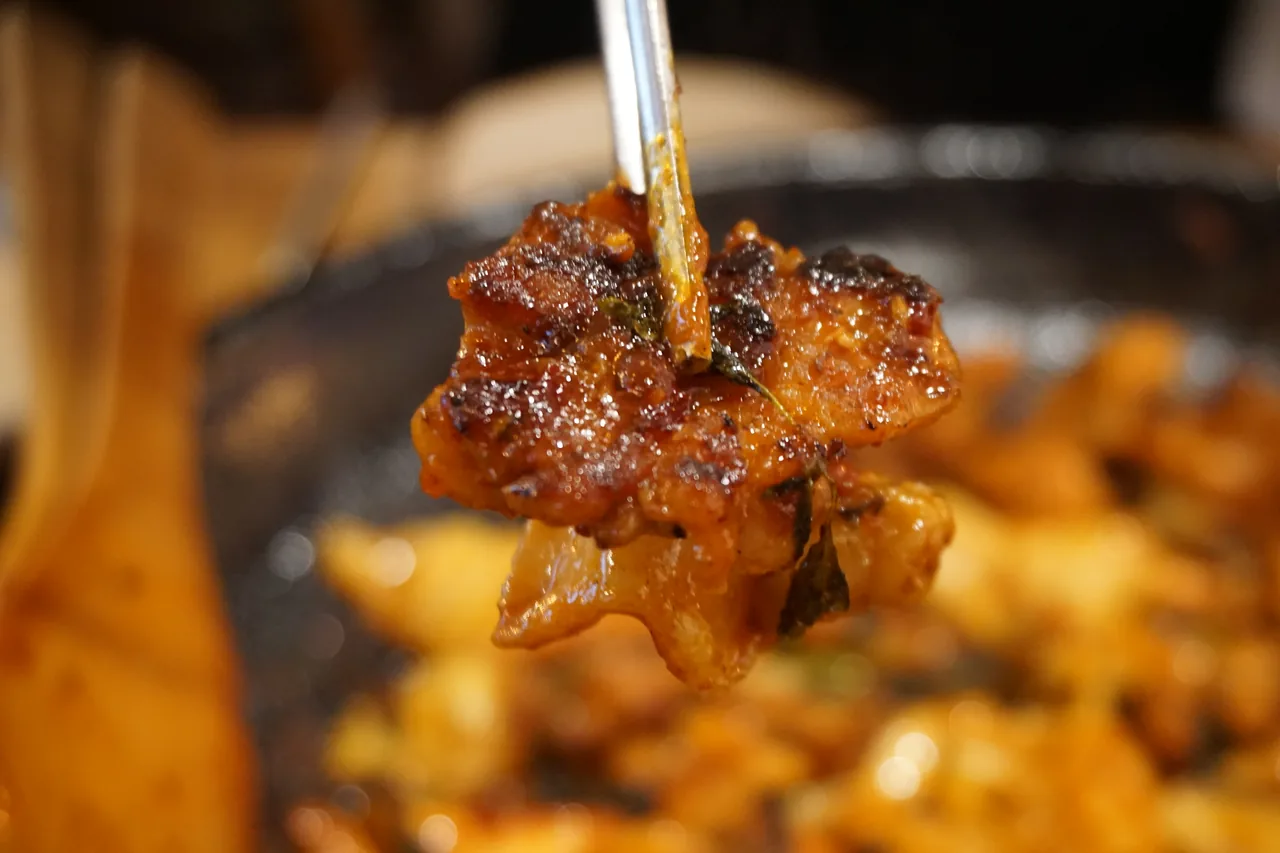 직화 닭갈비 한 점을 들어 올린 모습